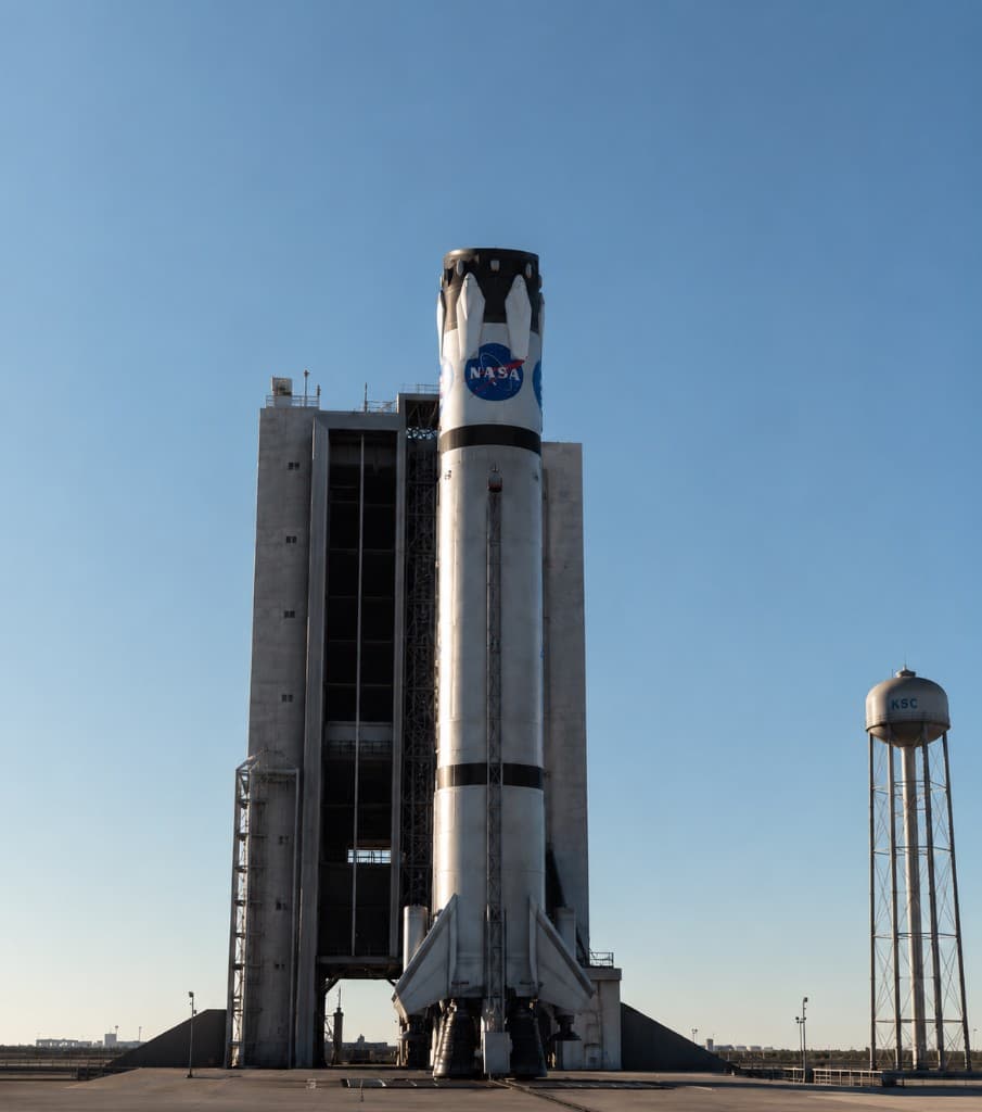 Kerbal X landable first stage on the pad, NASA meatball livery, vehicle assembly building behind
